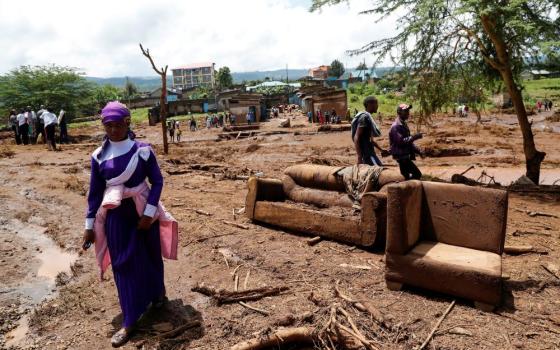A woman walks past couches in the Kamuchiri village of Mai Mahiu in central Kenya's Nakuru County April 29, 2024, after heavy flash floods wiped out several homes when a dam burst, following heavy rains. (OSV News photo/Thomas Mukoya, Reuters)