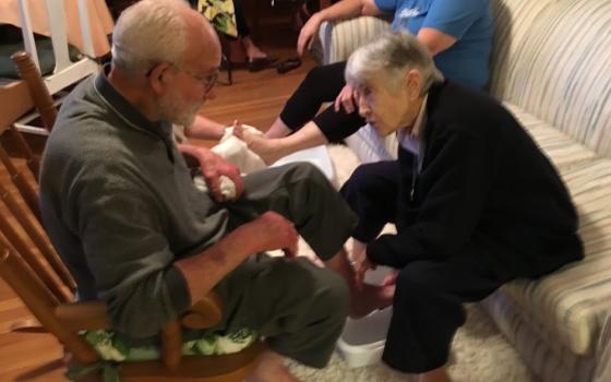 Sister of Charity Marie de Paul Combo washes the feet of Christian Brother Louis Rodeman, longtime leader at Kansas City's Holy Family Catholic Worker House, during a Holy Thursday Seder service. 