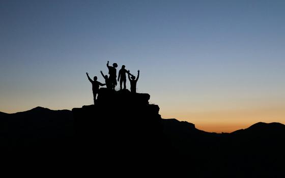 Silhouette of a group of people on a mountain (Unsplash/Natalie Pedigo)