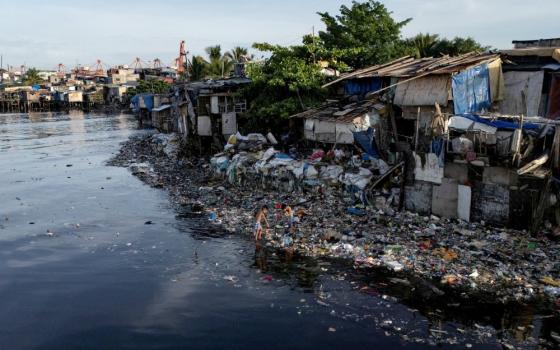 A drone view shows children picking through washed-up garbage along the polluted Pasig River in Manila, Philippines on June 5, 2025. (OSV News/Reuters/Eloisa Lopez)