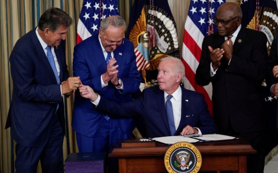 President Joe Biden hands the pen he used to sign the Democrats' landmark climate change and health care bill to Sen. Joe Manchin, D-W.Va., in the State Dining Room of the White House in Washington, Aug. 16. (AP/Susan Walsh)