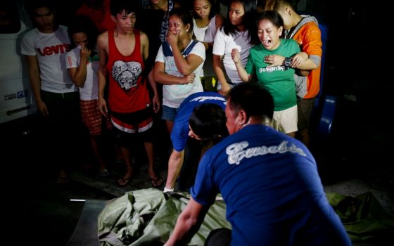 A female relative cries as the body of a Filipino killed in an anti-drug operation is carried away in 2016 in Manila. (CNS/EPA/Rolex Dela Pena)