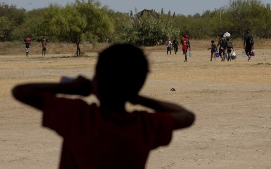 A boy watches other Haitians walk toward the Rio Grande, where many crossed into Del Rio, Texas, from an immigrant camp in Ciudad Acuña, Mexico, Sept. 22. (Nuri Vallbona)