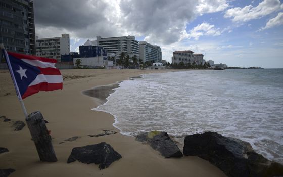 A Puerto Rican flag flies on an empty beach at Condado Beach May 21, 2020, in San Juan, Puerto Rico. (AP/Carlos Giusti, File)