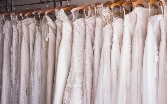 Wedding dresses hanging on a rack (Unsplash/Charisse Kenion)