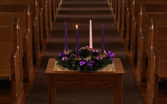 A lit candle is seen on a wreath for the first Sunday of Advent in this illustration photo. (CNS/Gregory A. Shemitz)