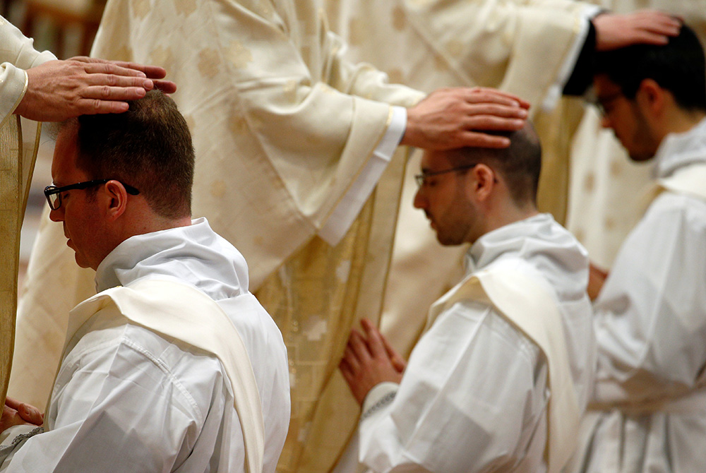 Priests put their hands on the heads of newly ordained priests during an ordination Mass celebrated by Pope Francis May 12, 2019, in St. Peter's Basilica at the Vatican. (CNS/Reuters/Yara Nardi)