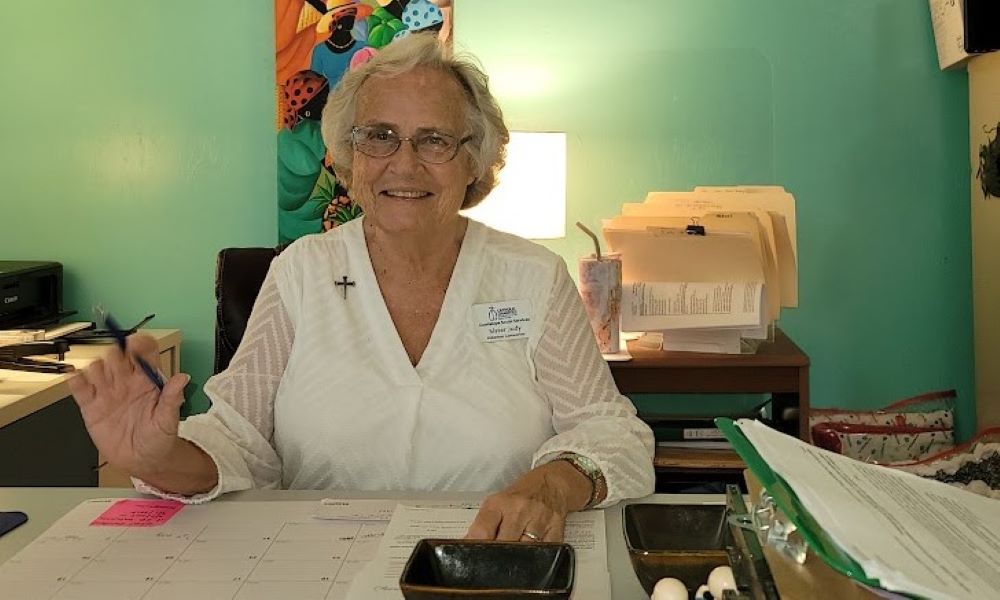 Woman sits at desk.