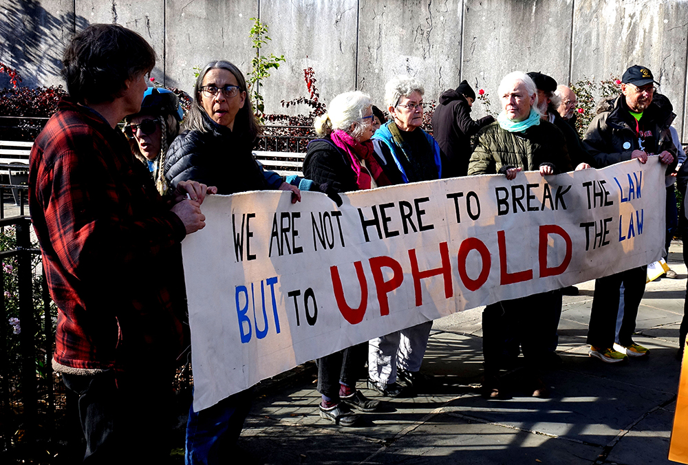 A group of Catholic activists block the entrance to the United States Mission to the United Nations in New York City on Nov. 30. (Felton Davis)