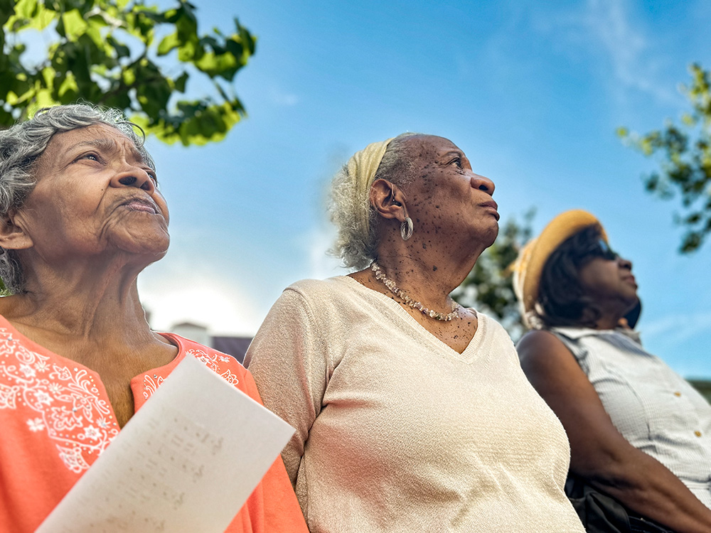 From left: Dorothy Gray, Joan Tillery and Gail Louis listen during a June 19 ceremony outside Holy Trinity Catholic Church in Washington, D.C., unveiling a plaque acknowledging "sins of racism" that took place there in the late 1800s and early 1900s that led Black parishioners to leave and establish a new parish nearby. Descendants of parishioners who left were present for a Mass and a ceremony and later spent time with modern-day Holy Trinity parishioners. (NCR photo/Rhina Guidos)