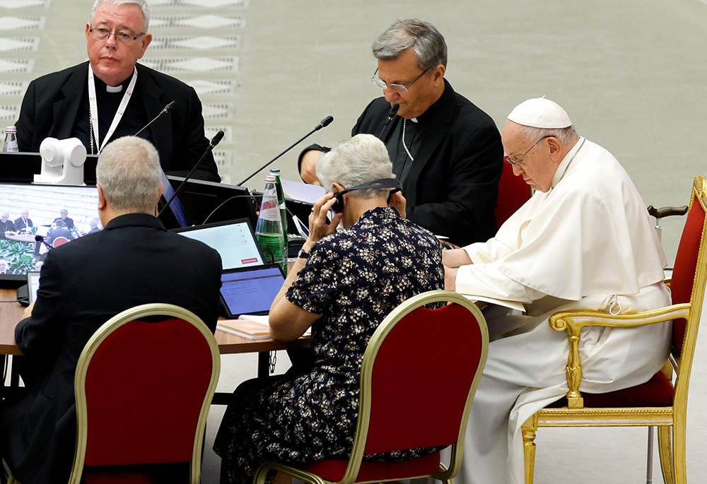 Pope Francis and leaders of the assembly of the Synod of Bishops listen to a speaker in the Vatican's Paul VI Audience Hall on Oct. 13, 2023. (CNS photo/Lola Gomez)