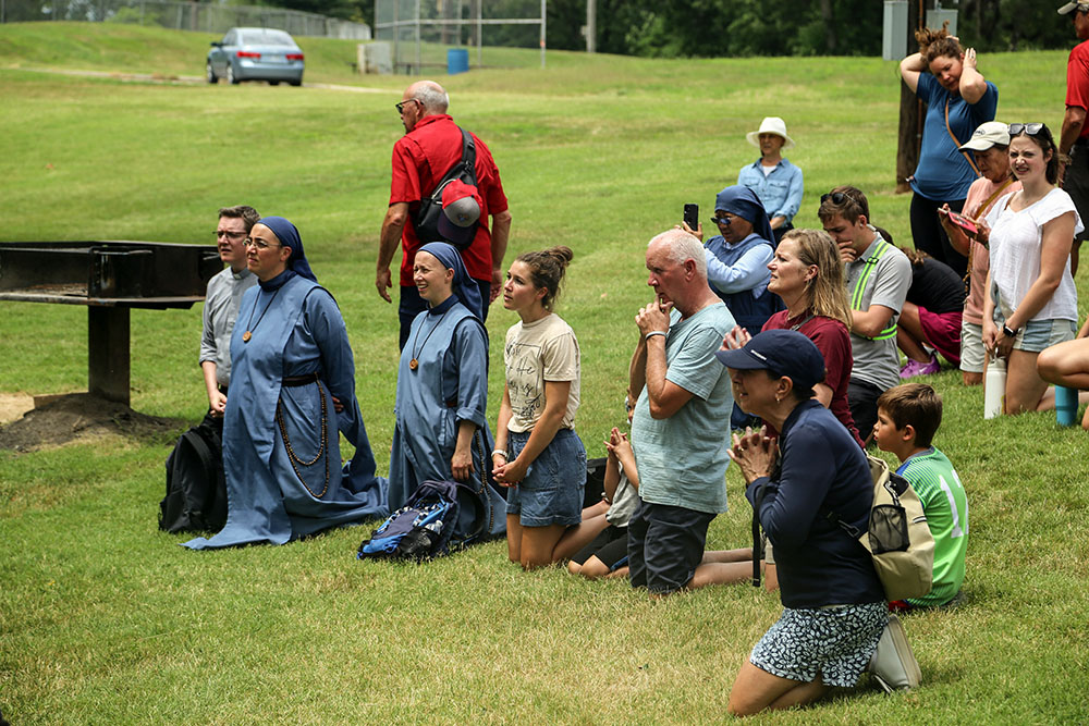 Pilgrims kneel for benediction in Rosedale Park in Kansas City, Kansas, as the St. Junipero Serra Route of the National Eucharistic Pilgrimage processed along various stretches of Mission Road in the Archdiocese of Kansas City, Kansas, June 28, playing on the theme "Mission." (OSV News/Megan Marley)