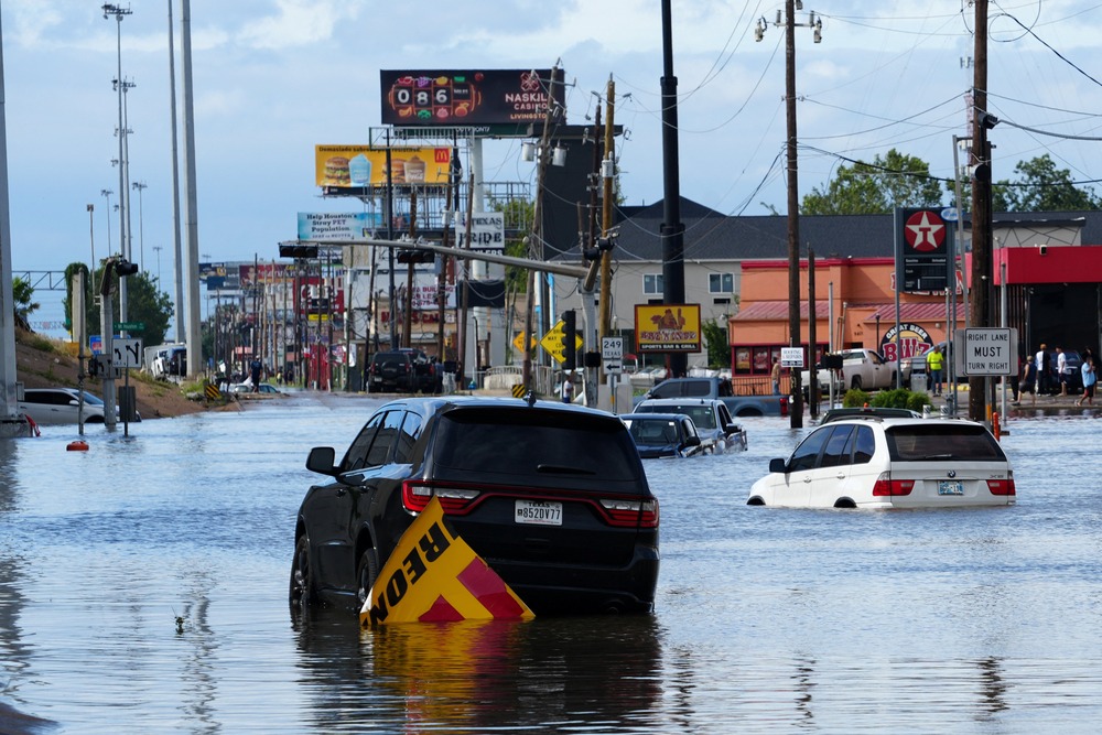 Major road flooded, floating cars. 