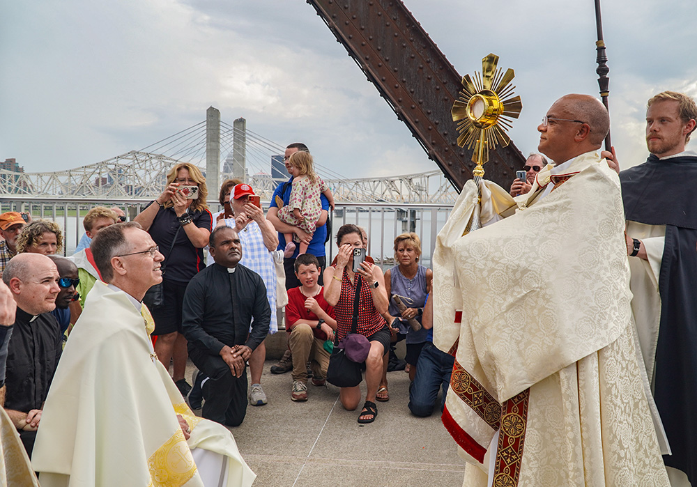 Archbishop Shelton Fabre of Louisville, Kentucky, transfers the monstrance to Archbishop Charles Thompson of Indianapolis during a eucharistic procession across the Ohio River's Big Four Bridge July 9. The procession marked the end of the National Eucharistic Pilgrimage's route through the Louisville Archdiocese. The pilgrimage was making its way next through southern Indiana and into Indianapolis. (OSV News/The Record/Marnie McAllister)
