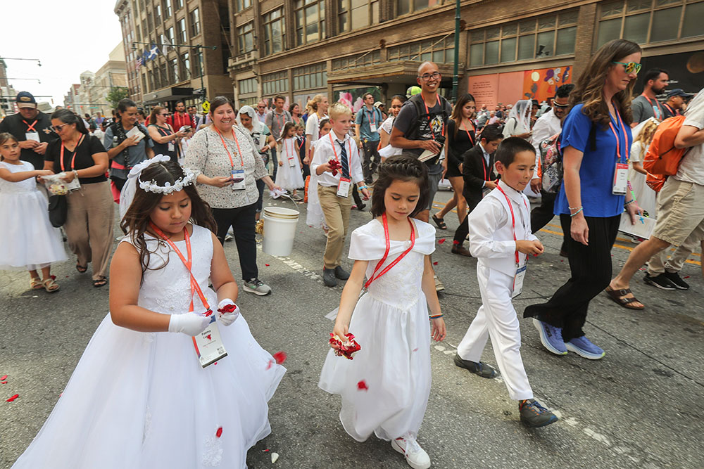 Young pilgrims throw rose petals during the final eucharistic procession of the National Eucharistic Congress in downtown Indianapolis July 20. (OSV News/Bob Roller)