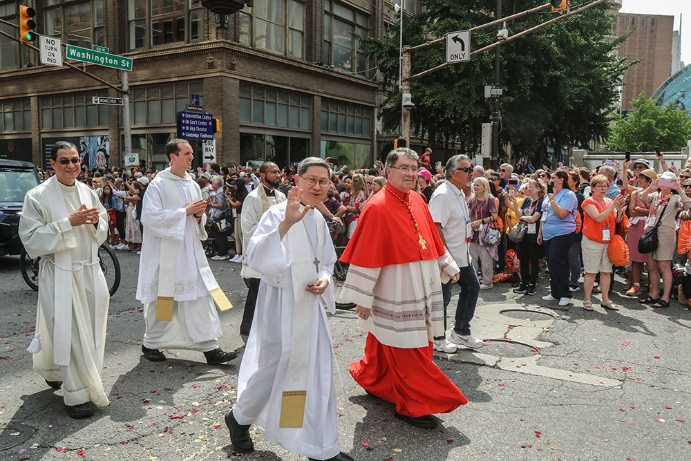 Cardinal Luis Antonio Tagle, Pope Francis' special envoy to the National Eucharistic Congress, waves alongside Cardinal Christophe Pierre, the papal nuncio to the United States, as they join the final eucharistic procession of the congress in downtown Indianapolis July 20. (OSV News/Bob Roller)