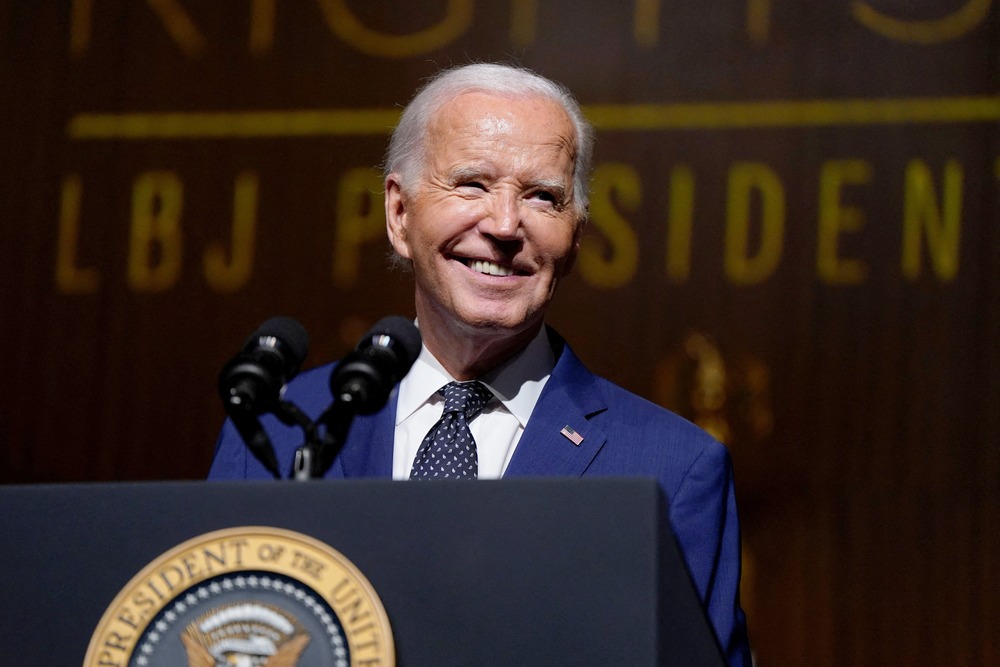 Biden smiles from behind podium. 