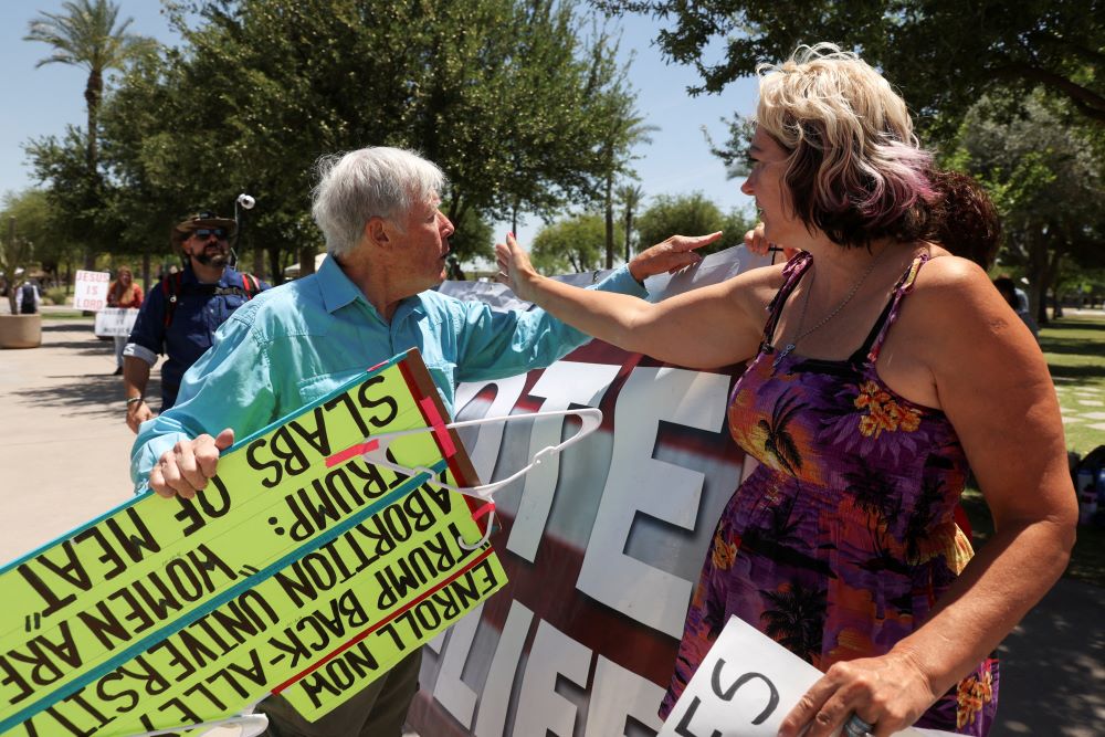 An abortion opponent and a supporter of legal abortion argue outside the Arizona State Capitol in Phoenix as the state Senate votes to repeal its near total ban on abortion May 1. 