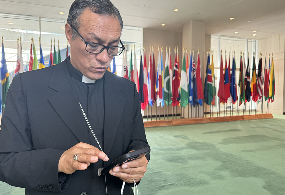 Auxiliary Bishop Lizardo Estrada Herrera of Cuzco, Peru, who is general for the Latin American bishops' council looks over his notes at the United Nations, July 9 in New York City. Estrada spoke with officials at the UN about the dire socioeconomic situations in Latin America and the Caribbean that are driving mass migration. (NCR photo/Rhina Guidos)