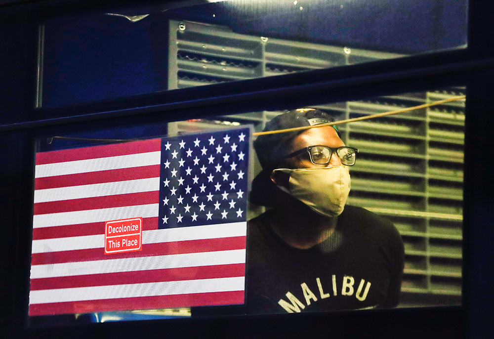 On May 29, 2020, in the Brooklyn borough of New York, a demonstrator who was arrested waits in the back of a bus during a protest against the death of George Floyd, a black man who was killed while being restrained by a Minneapolis police officer on Memorial Day that year. (AP/Frank Franklin II)