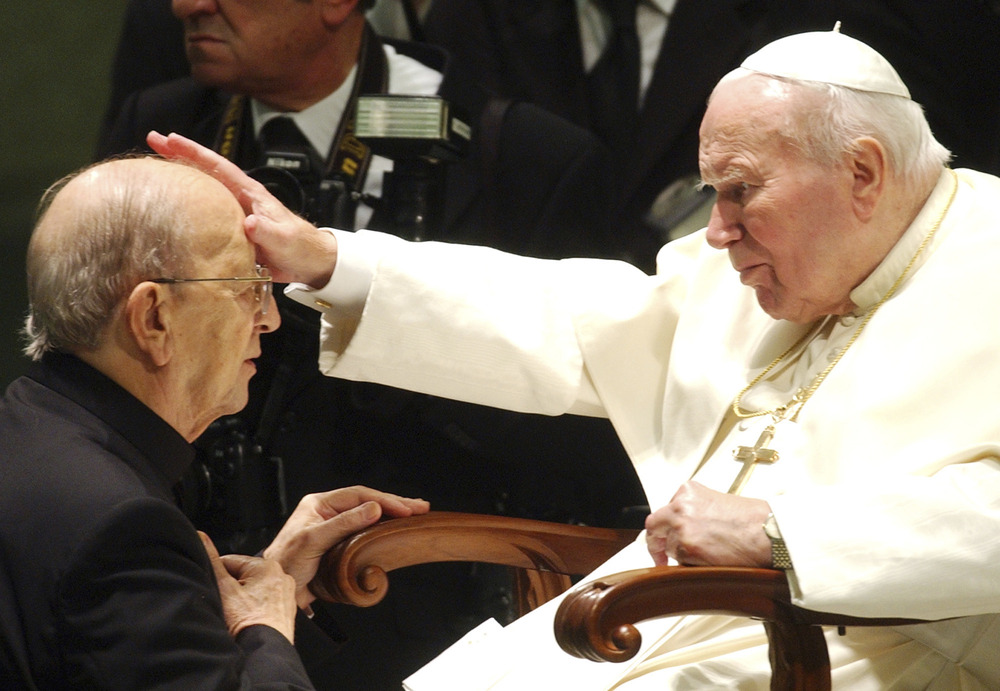 Elderly John Paul II, seated, lays hands on Fr. Maciel's forehead, as he kneels for blessing. 