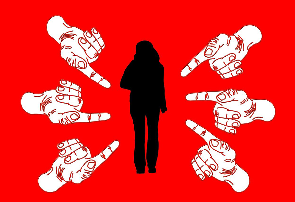 An illustration shows the black silhouette of a woman, surrounded by drawings of white-colored hands pointing at her, all against a red background. (Pixabay/geralt)