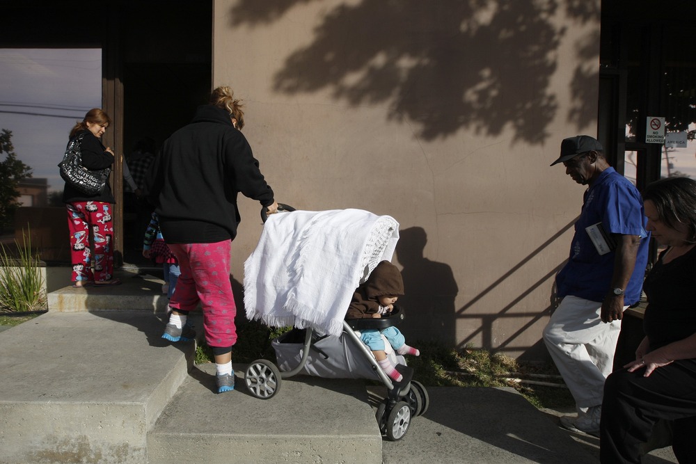 Family pulls stroller up cement stairs. 