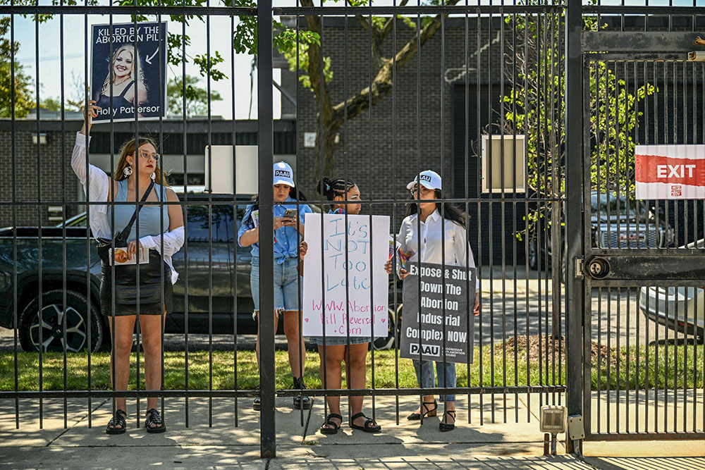 Pro-life protesters hold placards outside of a Planned Parenthood mobile clinic nearby the United Center, the host venue of the Democratic National Convention in Chicago Aug. 19. (OSV News/Reuters/Vincent Alban)