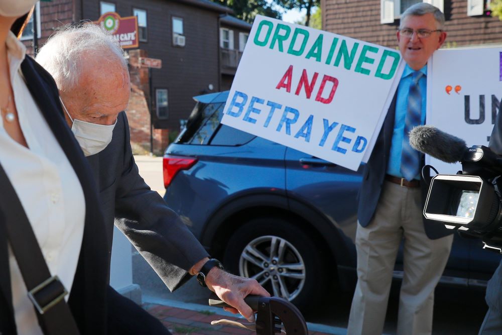 Protesters greet former Cardinal Theodore McCarrick as he arrives at court.