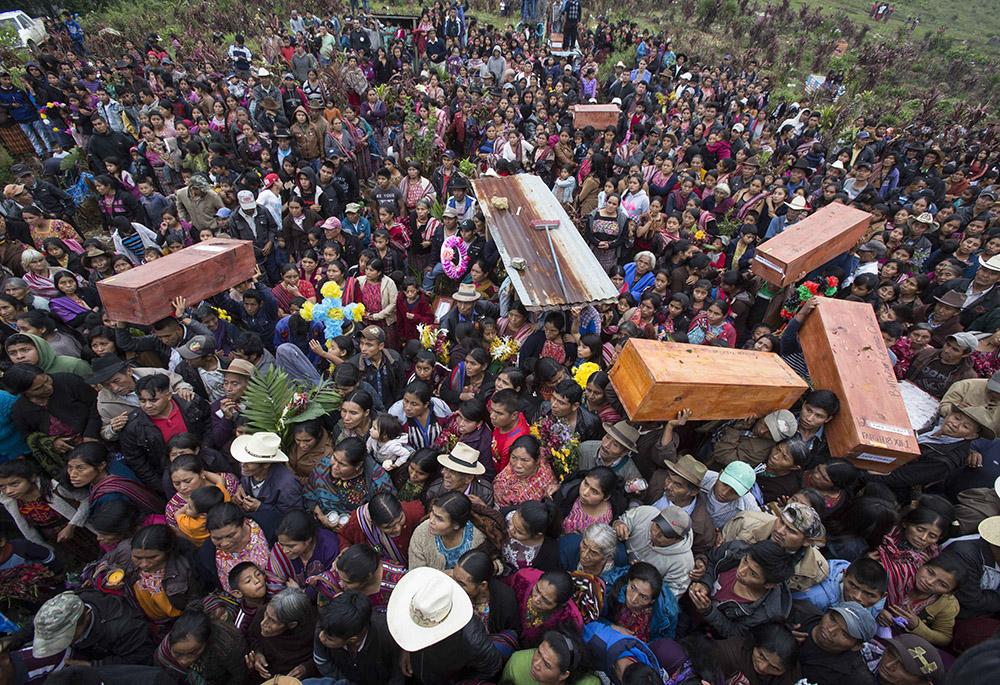 In this Nov. 30, 2017, photo, locals carry the remains of family members who were killed during the civil war, to finally be buried in Santa Avelina, Guatemala. In 1980 the army formed one of the first model villages in Santa Avelina, located in the heart of Ixil territory in the department or province of Quiche. But without access to doctors, a healthy diet and freedom, people began to die. (AP photo/Luis Soto)