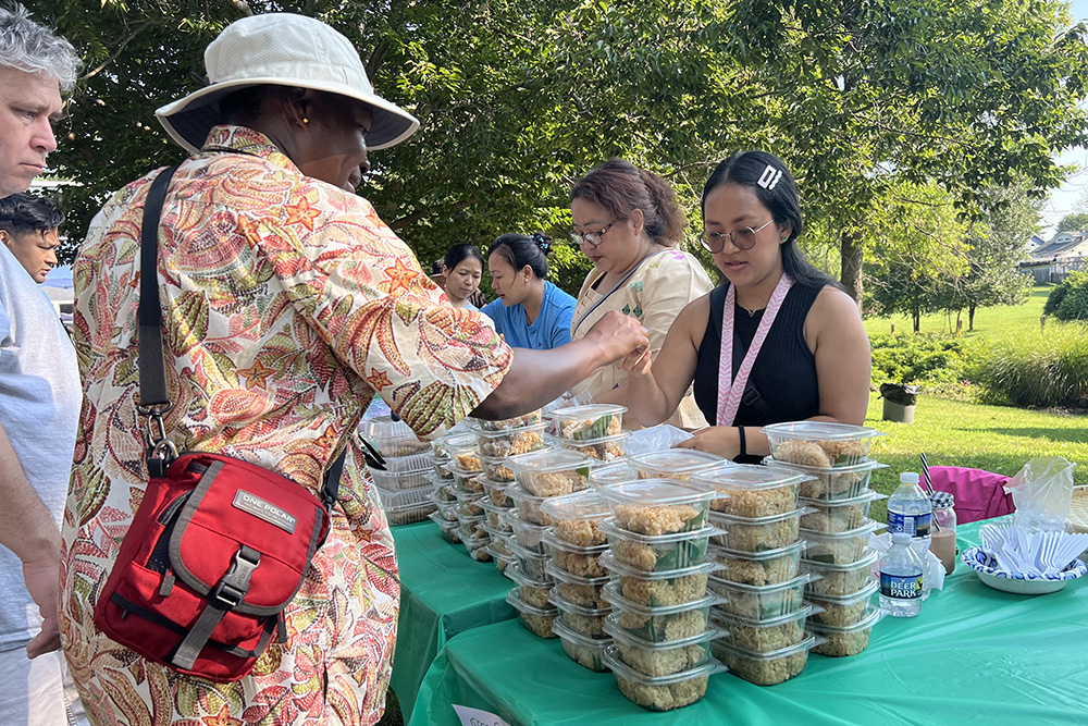 New and longtime parishioners share food at the first Burmese food fair at Our Lady of Victory parish in Baltimore. Burmese parishioners made dishes such as coconut sticky rice for the fundraiser. Many Burmese refugees have found a home at the parish after escaping persecution in Myanmar. (Matt Palmer)