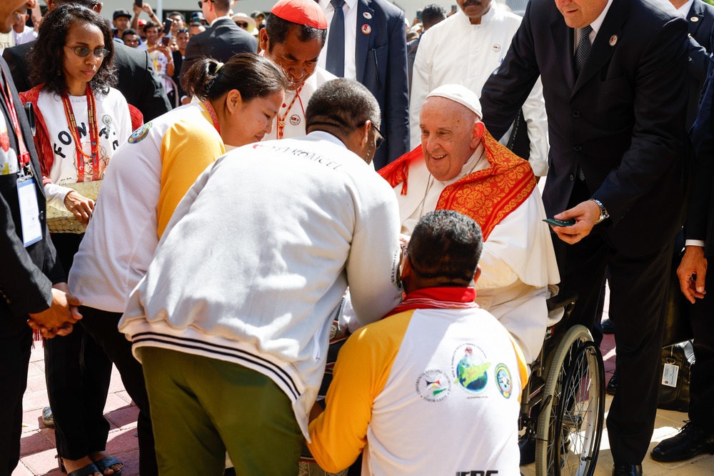 Francis in wheelchair greets people.