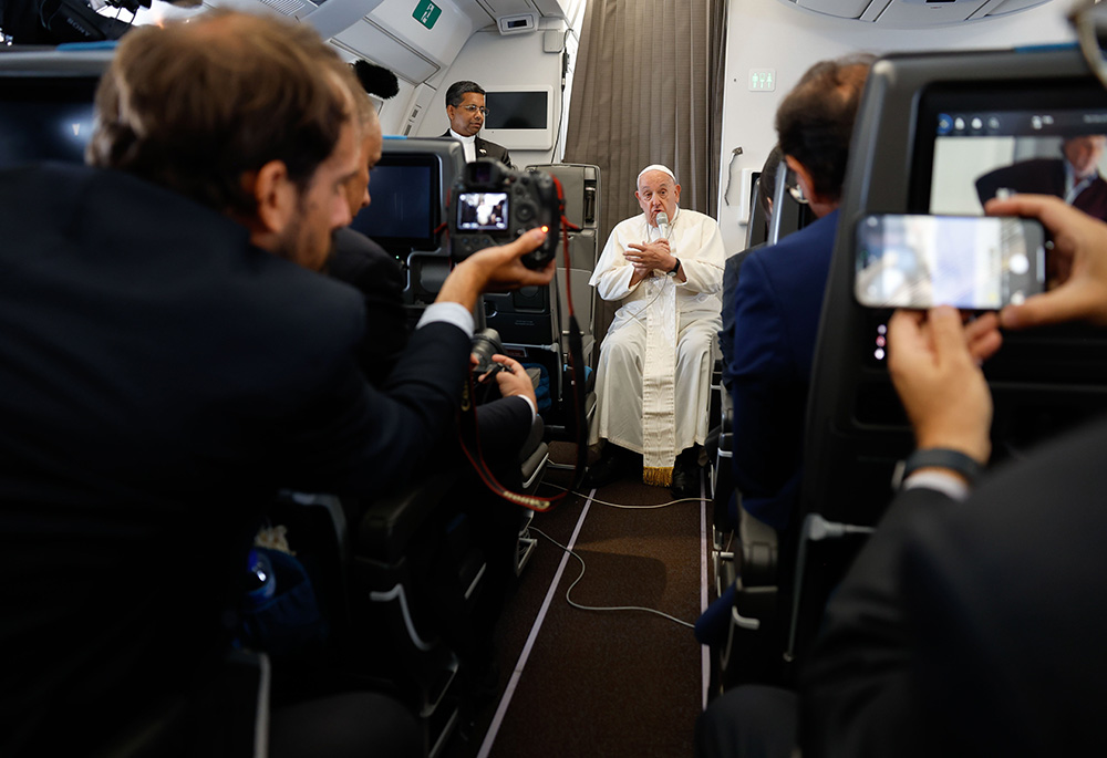 Pope Francis answers a question from a journalist aboard his flight back to Rome Sept. 13, after visiting Indonesia, Papua New Guinea, Timor-Leste (or East Timor) and Singapore. It was his 45th and longest international trip. (CNS/Lola Gomez)