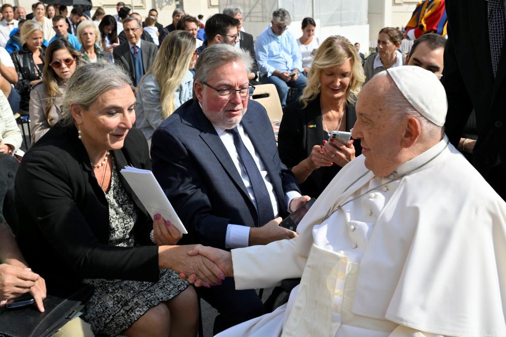 Lynn Discenza gives Pope Francis a book containing a collection of life stories written by LGBTQ+ Catholics and parents of LGBTQ+ kids from her parish, St. Patrick-St. Anthony in Hartford, Connecticut, during her meeting at St. Peter's Square at the Vatican on Sept. 18. (Vatican Media)