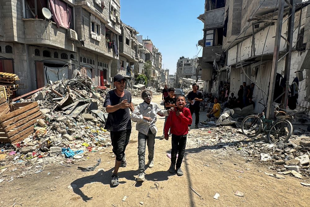 Palestinians react at the site of an Israeli strike that destroyed several houses in Khan Younis in the southern Gaza Strip.