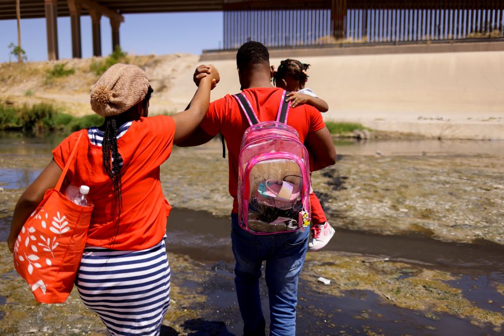 An asylum-seeking migrant family from Haiti cross the Rio Bravo.