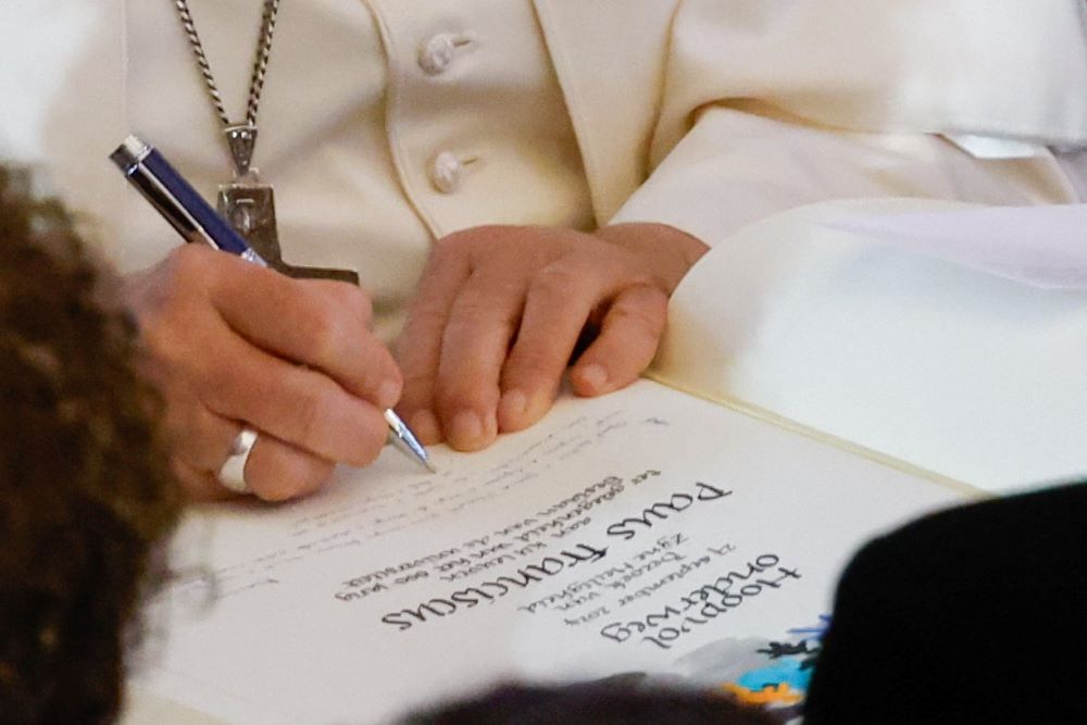 Pope Francis signs the guest book at the Catholic University of Leuven, a Catholic research university in the city of Leuven, Belgium, Sept. 27. (CNS/Lola Gomez)