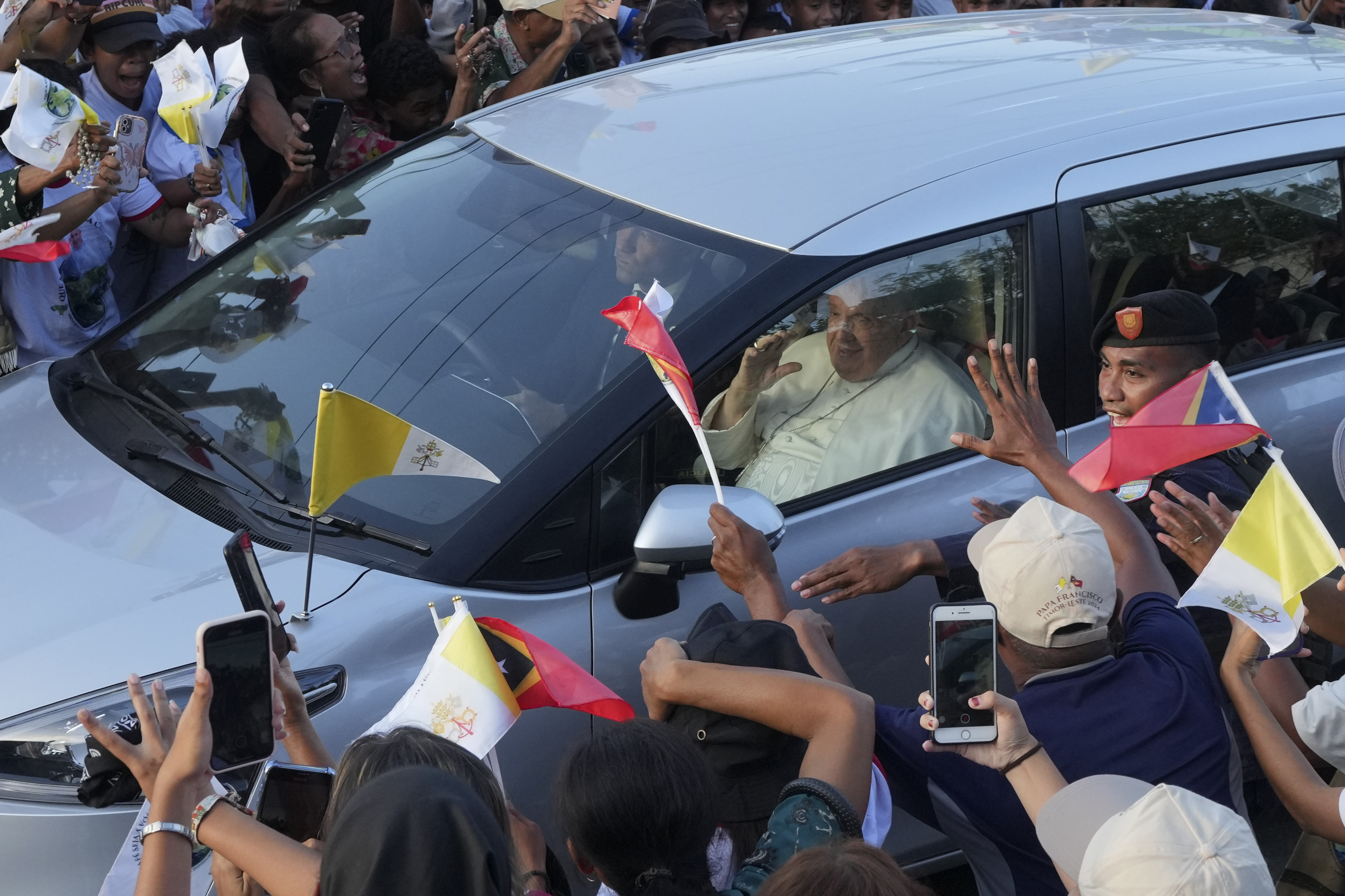 People greet Pope Francis as he travels in a car on way to the Presidential Palace in Dili, East Timor, Monday, Sept. 9. (AP photo/Firdia Lisnawati)