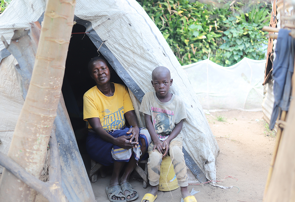 Flora Membe sits outside her tent with her grandson in Khumwanda displacement camp, July 16 in Busia, Kenya, after floods swamped her house. Many homeless people are crammed into overcrowded camps for internally displaced persons, struggling to access necessities like food, clean water, medicine and sanitation. (GSR photo/Doreen Ajiambo)