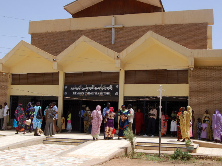 Exterior of cathedral with people out front. 