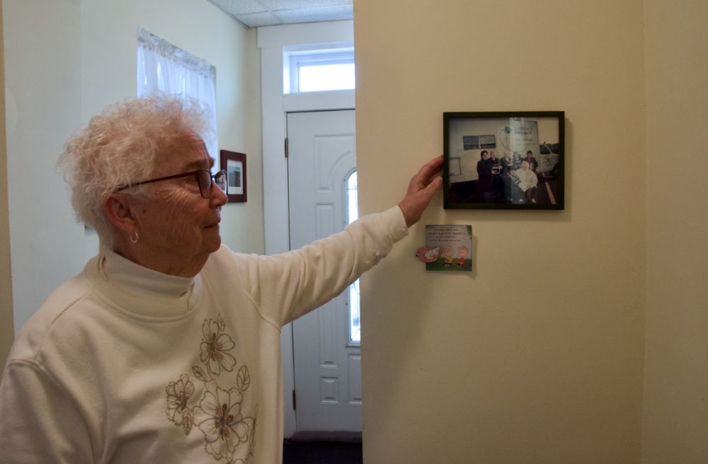 Sr. Marian Behrle shows a photo of the Sisters of St. Joseph Welcome Center's early mission: a van that would visit different sites to serve the Albanian community and teach literacy classes.  Behrle is the center's finance and operations coordinator. 