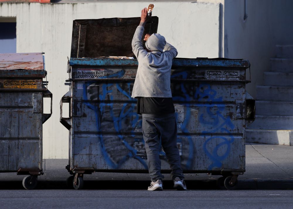 A man pulls food out of a dumpster in San Francisco May 19. 