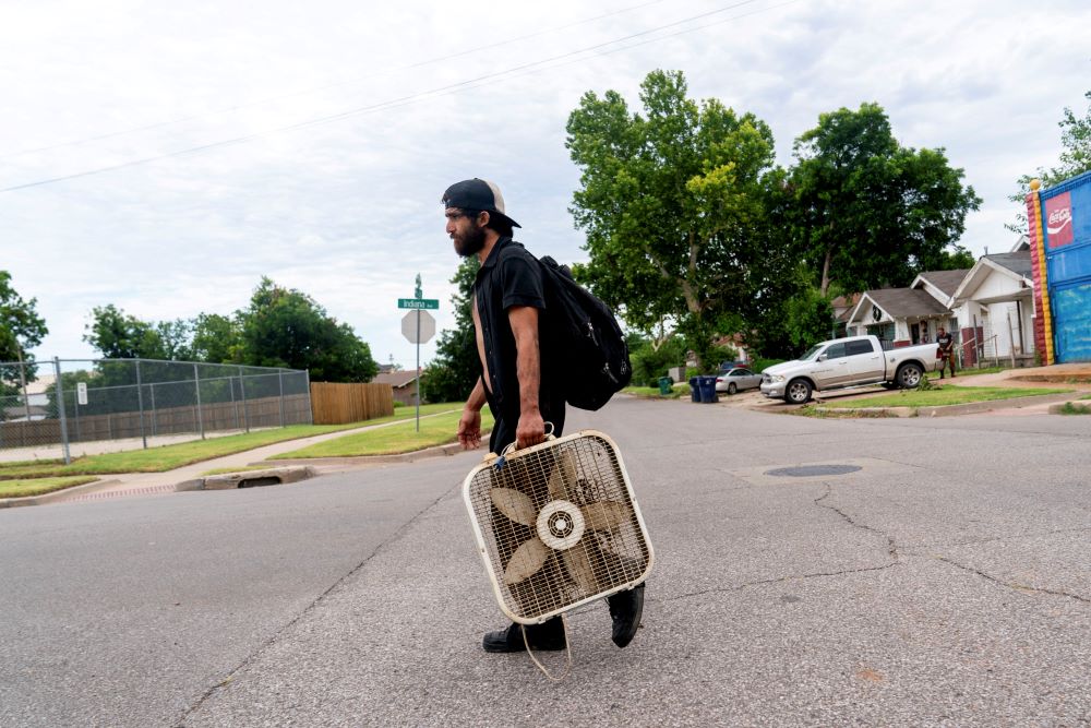 James Robinson carries a fan back to his home during an excessive heat warning in Oklahoma City June 26. 