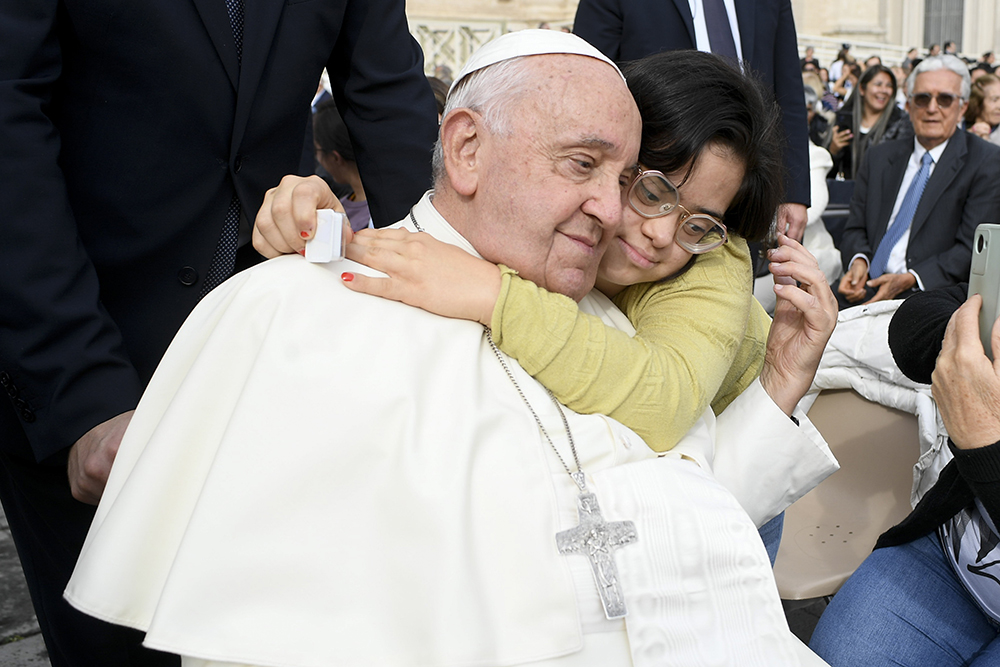 Pope Francis receives a hug from a child after his weekly general audience in St. Peter's Square at the Vatican Oct. 9, 2024. (CNS/Vatican Media)