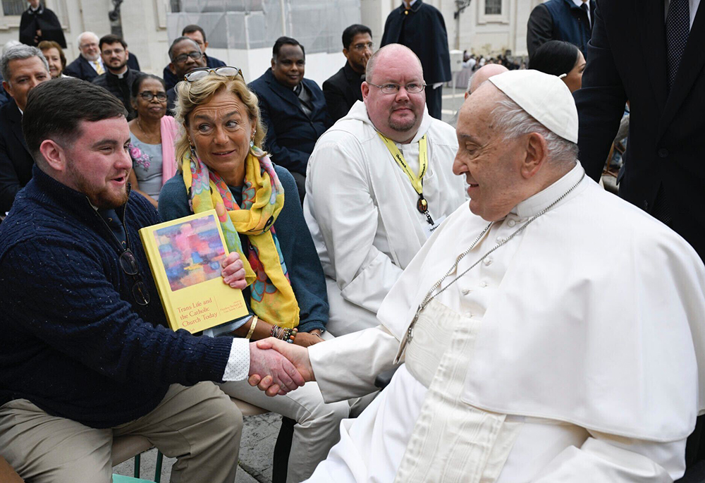 George White shakes hands with Pope Francis Oct. 23 after a general audience in St. Peter's Square at the Vatican. White and Br. Christian Matson, right, wrote personal letters to the pope, which they inserted into the book Trans Life and the Catholic Church Today as their gift to the pontiff. (Courtesy of George White/Vatican Media)