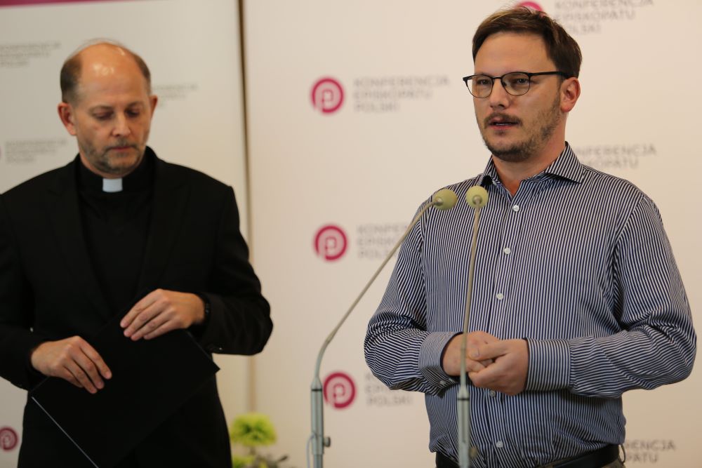 Clergy sex abuse survivor speaks while bishop looks on.