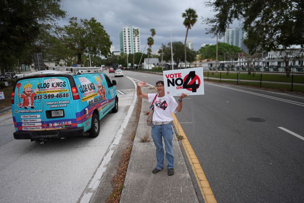 Sonja Kahkonen, an anti-abortion Catholic, holds a sign urging voters to reject Amendment 4, which would have enshrined abortion rights in Florida.