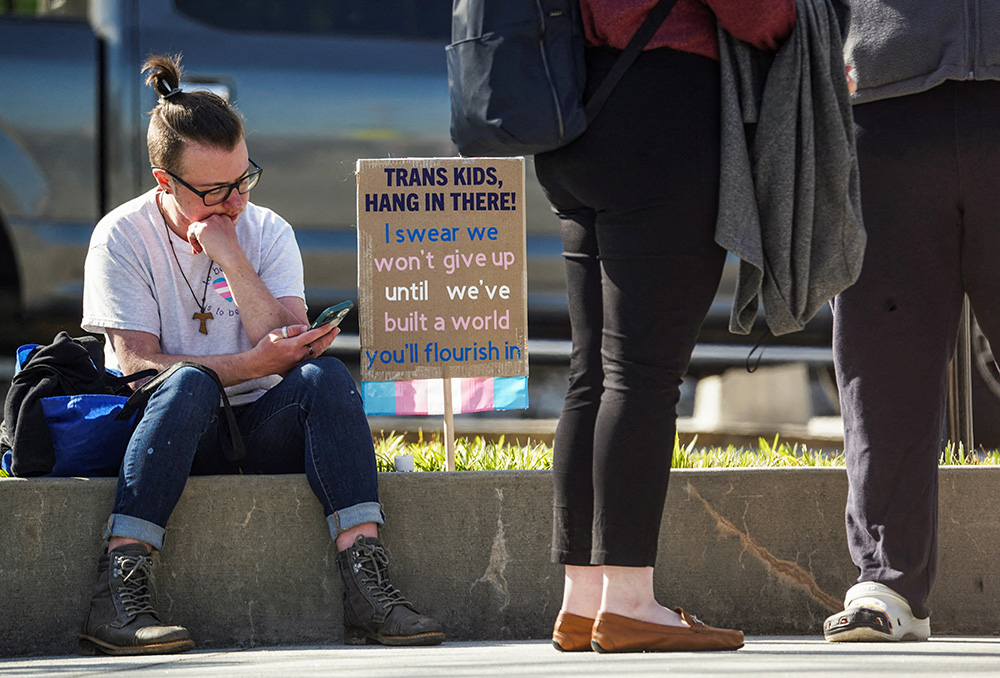 A young demonstrator sits during a protest rally outside the Georgia Capitol in Atlanta March 20, 2023, after the state House and Senate voted to prohibit most surgeries and hormone replacement therapies for minors seeking to change their gender. Georgia's governor subsequently signed the bill into law. (OSV News/Reuters/Megan Varner)