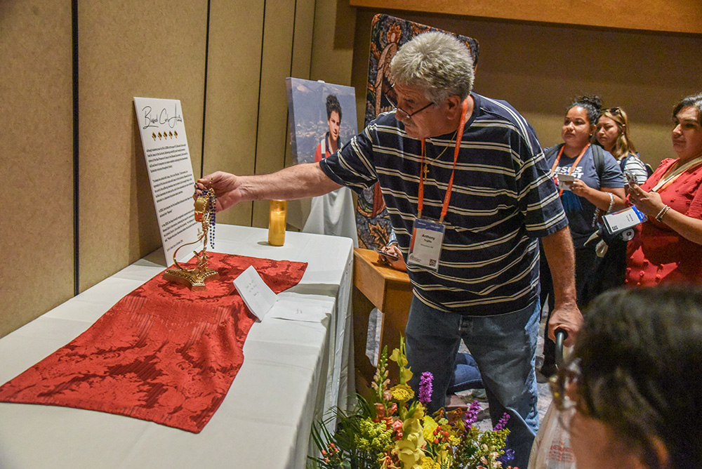 Anthony Trujillo of Albuquerque, N.M., places a rosary against a reliquary holding a relic of Blessed Carlo Acutis July 19, 2024, in the relic chapel of the National Eucharistic Congress at the Indiana Convention Center in Indianapolis. (OSV News/The Criterion/Sean Gallagher)