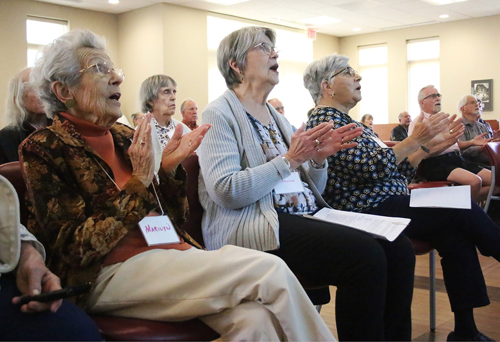 Spiritus community members Marilyn Nagle, Darlene Stout and Grace D'Amato clap during a Nov. 3 prayer service in Beavercreek, Ohio. (NCR photo/Dennis Sadowski)